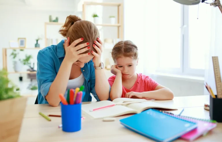 Mutter und Kind sitzen verzweifelt am Tisch vor den Hausaufgaben