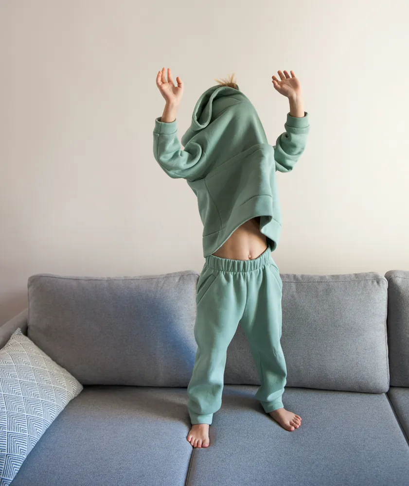 Kind steht auf Sofa und will nicht schlafen